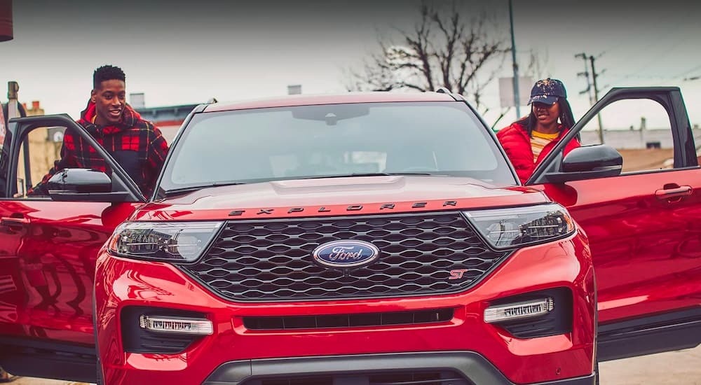 People are shown getting into a red 2023 Ford Explorer ST