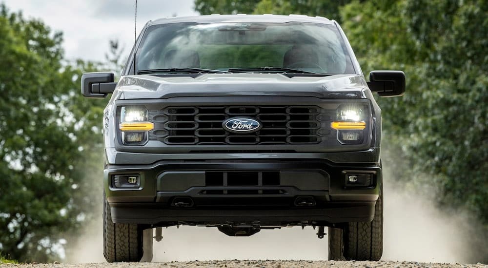 A grey 2024 Ford F-150 STX is shown from the front after leaving a dealer that has a Ford F-150 for sale