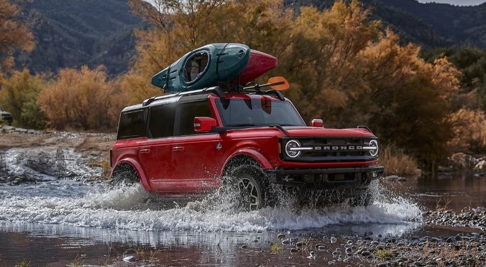 A red 2024 Ford Bronco Big Bend driving over a shallow lake