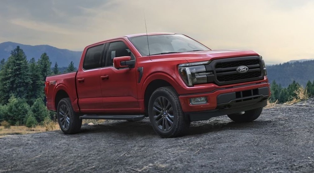 A red 2025 Ford F-150 Lariat parked off-road and angled right.