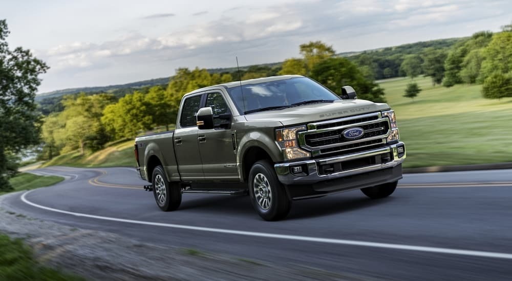Green 2021 Ford F-250 Super Duty driving on a winding road
