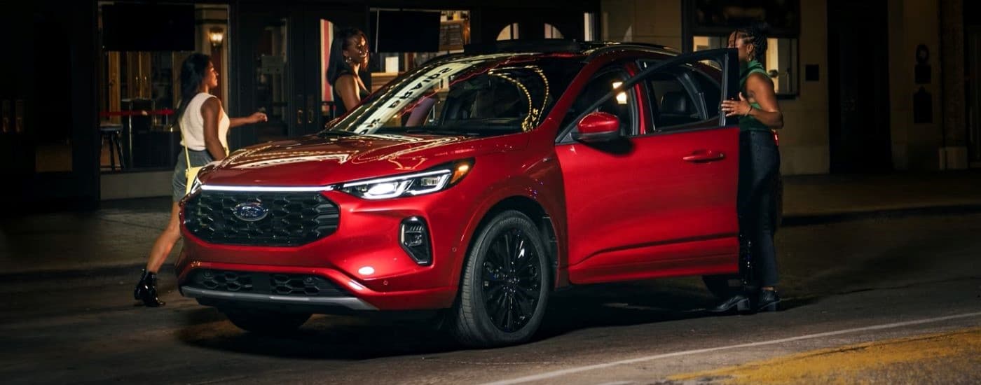 Red 2023 Ford Escape ST-Line parked by a curb.