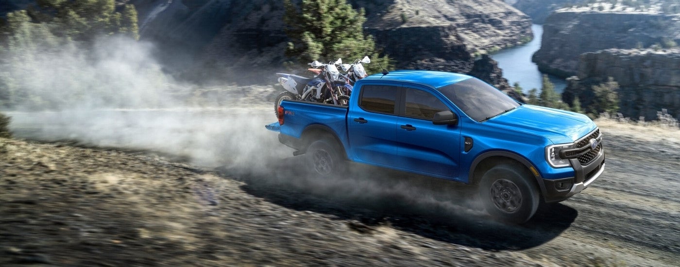 Blue 2026 Ford Ranger XLT driving down a dusty trail