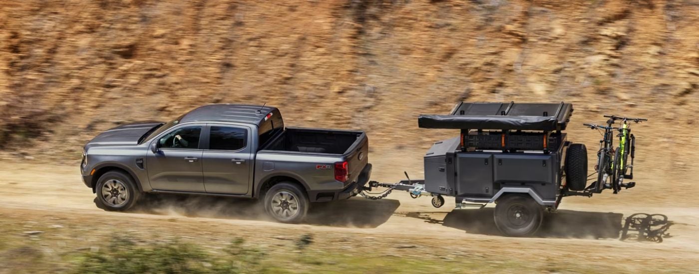 A gray 2026 Ford Raptor towing a trailer.