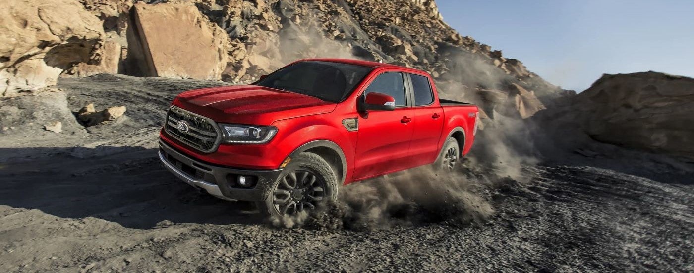 A red 2023 Ford Ranger FX4 kicking up dust.