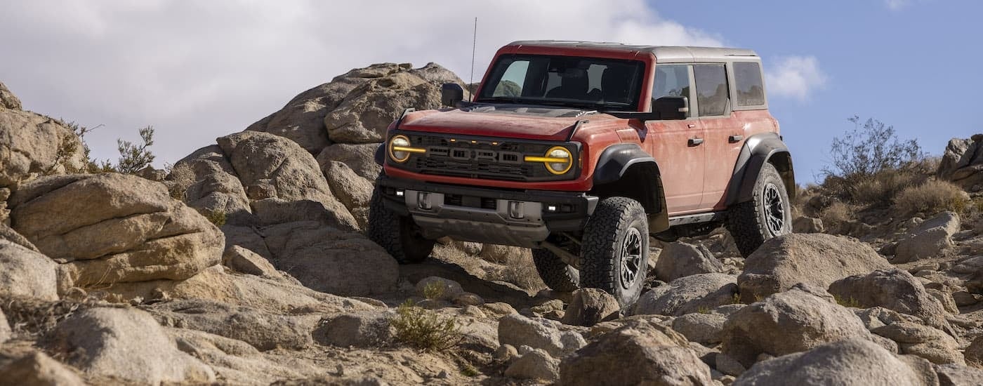 A red 2023 Ford Bronco Raptor is shown from the front at an angle.