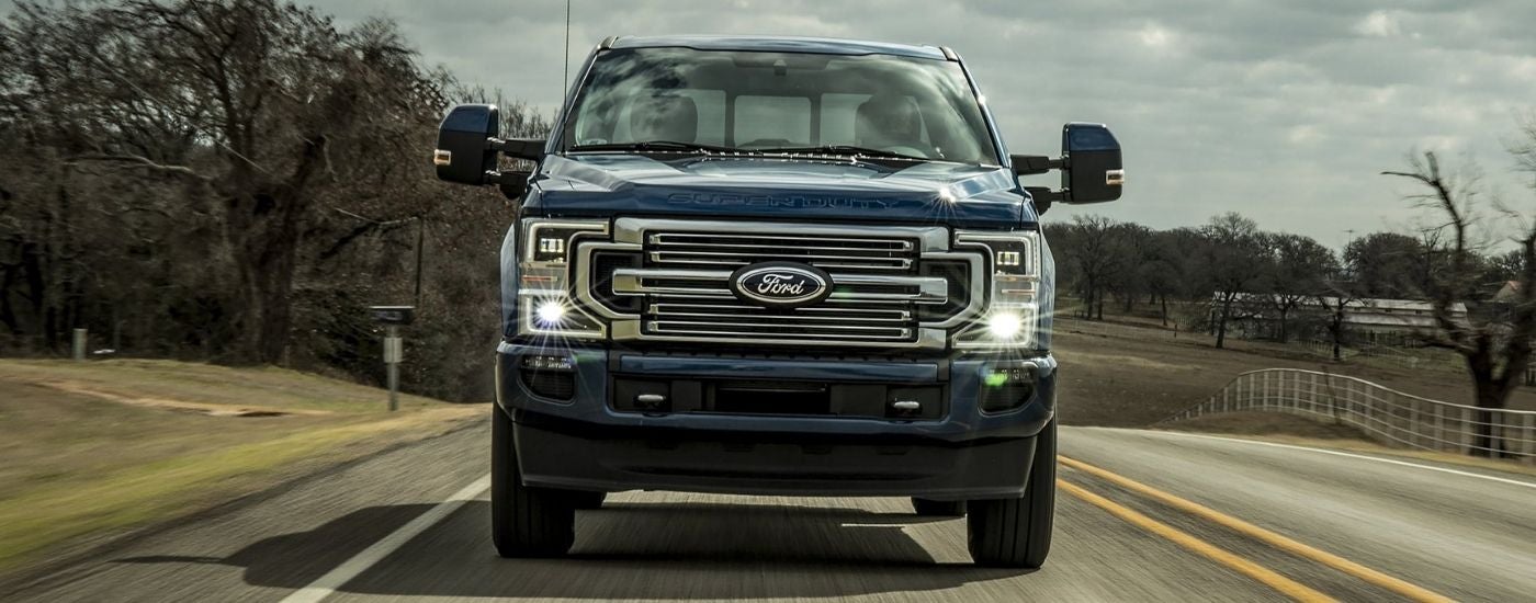 Blue 2021 Ford F-250 driving to look at Ford trucks for sale near Red Hook