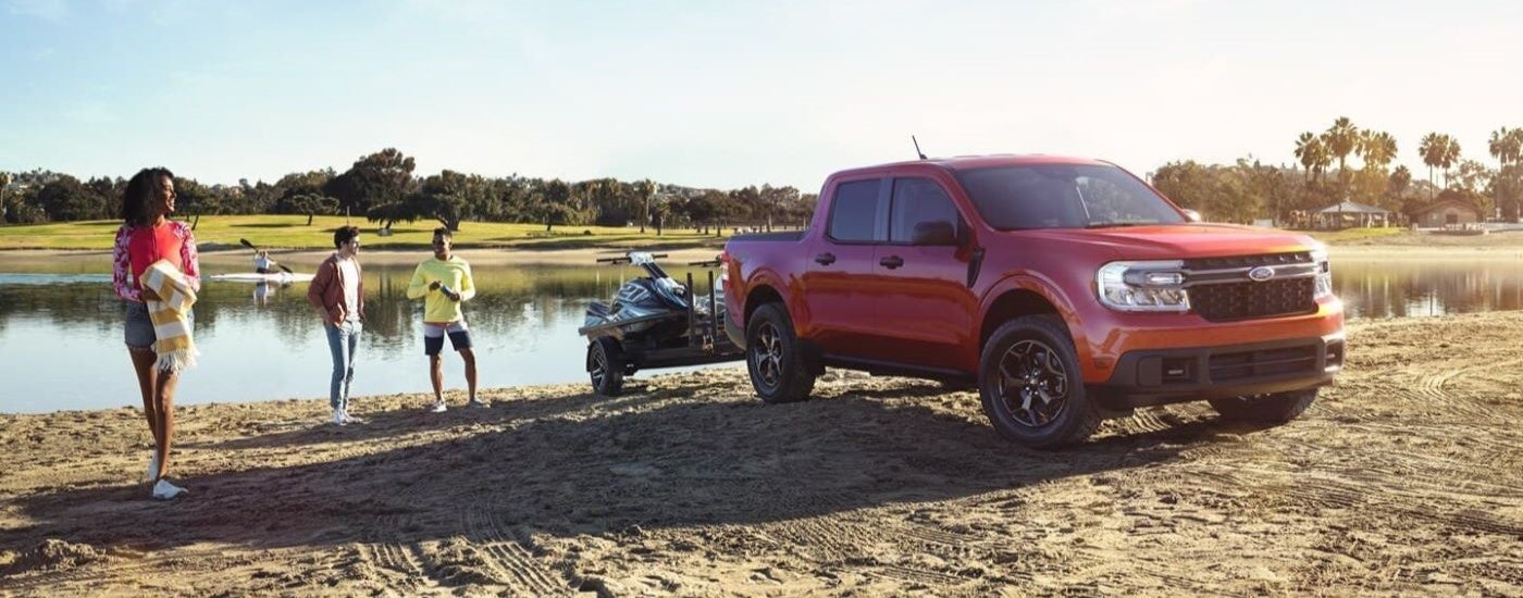 Red 2022 Ford Maverick parked near a lake